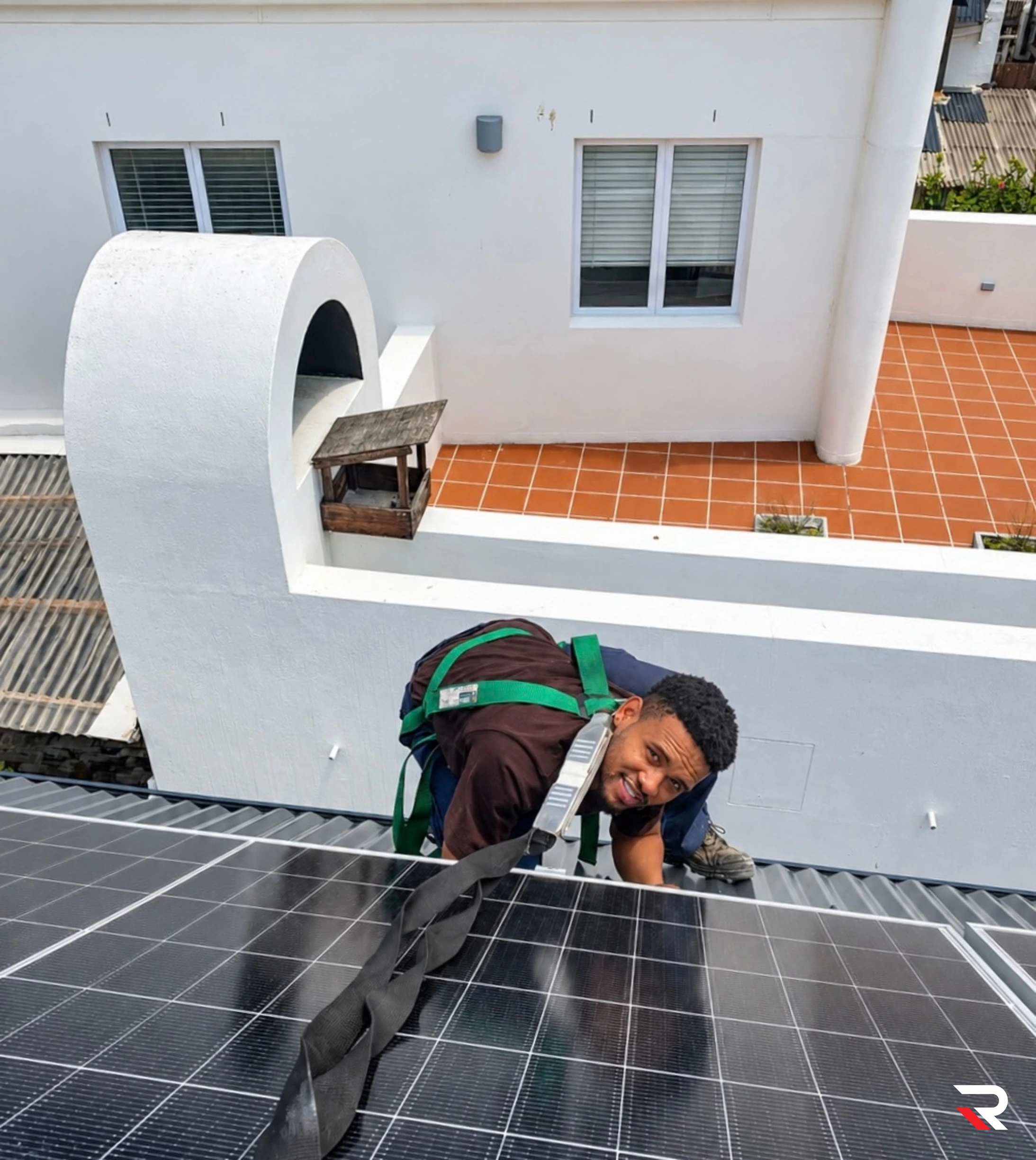 REDLINE solar installer working on a rooftop panel installation